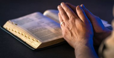 İncil 'in üzerine yemin ederim. Dua et. İncil 'i yakın plan aç. Din kavramı. Yüksek kalite fotoğraf. Hıristiyanlık, dua ve İncil okuma.