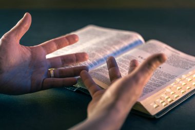 İncil 'in üzerine yemin ederim. Dua et. İncil 'i yakın plan aç. Din kavramı. Yüksek kalite fotoğraf. Hıristiyanlık, dua ve İncil okuma.