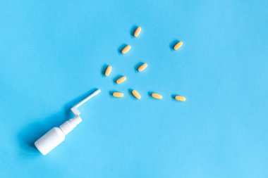 İlaç, sağlık ve eczane konsepti. Kopyalama alanı olan üst görünüm. Yüksek kalite fotoğraf. Sarı haplar, vitaminler. Burun spreyi.