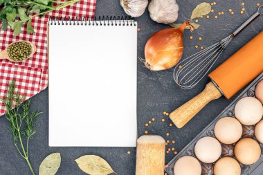 Boş defterle malzemeler pişiriyorum. Şifalı bitkiler ve baharatlarla dolu bir yemek tarifi kitabı. Yüksek kalite fotoğraf. Uzayı kopyala Üst manzara, düz yatış. Yemek pişirme hazırlığı.