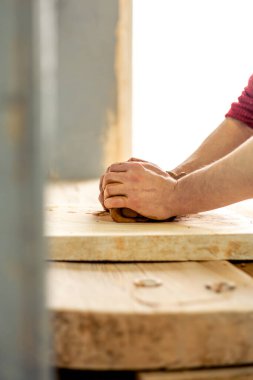 Seramikçi-çömlekçi iş başında. Çamurdan modelleme. Çömlekçiliğe hazırlanıyorum. Yüksek kalite fotoğraf. Sanat atölyesinde profesyonel çömlek yapımı. Çamur ellerinde.