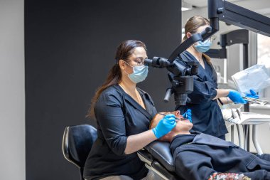 Kadın dişçi hastaların dişlerini tedavi eder. Profesyonel ekipmanlarla çalışan stomatolog. Yüksek kalite fotoğraf. Diş tedavisi. Diş dolguları ve bakımı tedavisi.