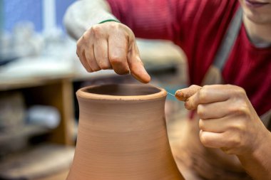 Erkek bir çömlekçi vazo yapıyor. Çömlek. Çamur modelliği. Yüksek kalite fotoğraf. Kendi ellerinle seramik yapıyorsun. Seramiklerin yapıldığı atölyede bir adam.