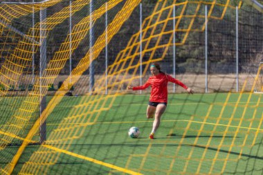 Sportif kız golü atıyor. Futbol konsepti. Futbol sahasındaki kız. Yüksek kalite fotoğraf. Kız futbolcu. Profesyonel futbol eğitimi..
