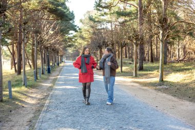 Parkta yürüyen iki kadın. Parkta bir patikada yürüyen arkadaşlar. Yüksek kalite fotoğraf. Doğa. Doğa yürüyüşü. Soğuk hava. Dışarıda eğlenmek için..