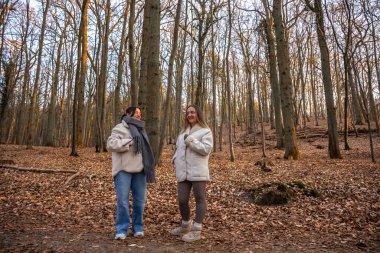 Ormanda yürüyüş yapan iki bayan arkadaş. Ormanda yürüyen arkadaşlar. Doğadaki insanlar. Yüksek kalite fotoğraf. Ormanda bir yürüyüş. Doğada rahatlama.
