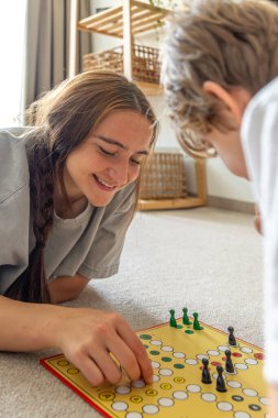 Küçük kardeşle masa oyunu oynayan bir kız. Masa oyunu. Yüksek kalite fotoğraf. Genç kız kardeşiyle masa oyunu oynuyor. Eğitim tahtası oyunu.