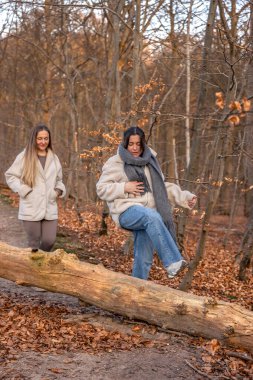 Ormanda yürüyen iki kadın. Orman. Doğa. Açık hava eğlencesi. Yüksek kalite fotoğraf. Ormanda bir patika boyunca yürüyen iki kadın. Soğuk hava.