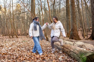 Ormanda yürüyüş yapan iki bayan arkadaş. Ormanda yürüyen arkadaşlar. Doğadaki insanlar. Yüksek kalite fotoğraf. Ormanda bir yürüyüş. Doğada rahatlama.