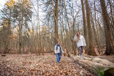Ormanda yürüyüş yapan iki bayan arkadaş. Ormanda yürüyen arkadaşlar. Doğadaki insanlar. Yüksek kalite fotoğraf. Ormanda bir yürüyüş. Doğada rahatlama.