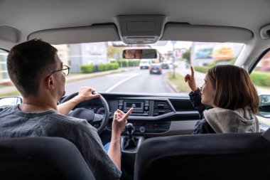 Bir adam ve çocuk şehirde araba sürerken bir arabanın içinde etkileşime girerler. Kız konuşma sırasında ileri doğru işaret ediyor..