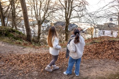 Ormanda yürüyüş yapan iki bayan arkadaş. Ormanda yürüyen arkadaşlar. Doğadaki insanlar. Yüksek kalite fotoğraf. Ormanda bir yürüyüş. Doğada rahatlama. Arka görünüm.