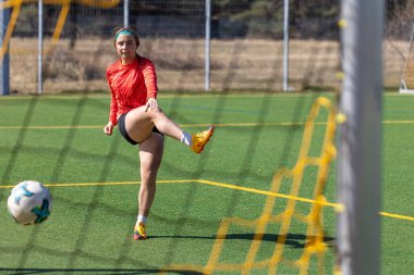 Sportif kız golü atıyor. Futbol konsepti. Futbol sahasındaki kız. Yüksek kalite fotoğraf. Kız futbolcu. Profesyonel futbol eğitimi. Metin için boşluk.