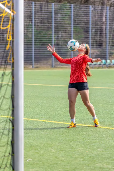 Futbol sahasındaki kız. Futbol antrenmanı. Aktif yaşam tarzı. Futbol konsepti. Yüksek kalite fotoğraf. Futbol formalı bir kız futbol topuyla oynuyor..