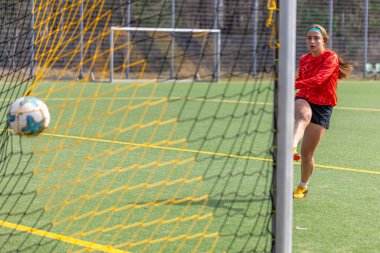 Sportif kız golü atıyor. Futbol konsepti. Futbol sahasındaki kız. Yüksek kalite fotoğraf. Kız futbolcu. Profesyonel futbol eğitimi..