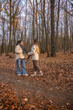 Ormanda yürüyüş yapan iki bayan arkadaş. Ormanda yürüyen arkadaşlar. Doğadaki insanlar. Yüksek kalite fotoğraf. Ormanda bir yürüyüş. Doğada rahatlama.