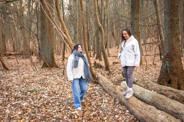 Ormanda yürüyüş yapan iki bayan arkadaş. Ormanda yürüyen arkadaşlar. Doğadaki insanlar. Yüksek kalite fotoğraf. Ormanda bir yürüyüş. Doğada rahatlama.