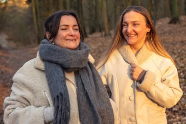 Ormanda yürüyüş yapan iki bayan arkadaş. Ormanda yürüyen arkadaşlar. Doğadaki insanlar. Yüksek kalite fotoğraf. Ormanda bir yürüyüş. Doğada rahatlama.