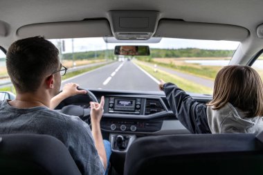 Çocuk açık kırlarda güneşli bir sürüş sırasında ileri doğru giderken insan araba sürer..