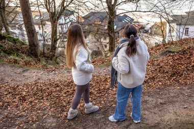 Ormanda yürüyüş yapan iki bayan arkadaş. Ormanda yürüyen arkadaşlar. Doğadaki insanlar. Yüksek kalite fotoğraf. Ormanda bir yürüyüş. Doğada rahatlama. Arka görünüm.