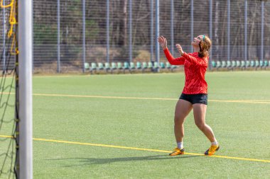 Futbol sahasındaki kız. Futbol antrenmanı. Aktif yaşam tarzı. Futbol konsepti. Yüksek kalite fotoğraf. Futbol formalı bir kız futbol topuyla oynuyor..