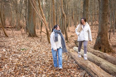 Ormanda yürüyüş yapan iki bayan arkadaş. Ormanda yürüyen arkadaşlar. Doğadaki insanlar. Yüksek kalite fotoğraf. Ormanda bir yürüyüş. Doğada rahatlama.