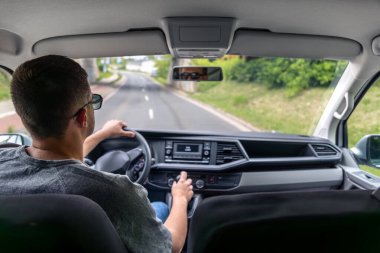 Boş bir şehir sokağında tek başına araba süren adam. Huzurlu ve odaklanmış sürüş anı.