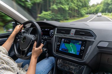 Bir kadın araba kullanırken direksiyonda seyir ekranı olan bir kadın. Hareket bulanıklığı hız ve konforu vurgular..