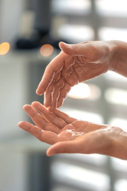 Avuçlarından yağ damlayan ellere dik bir bakış açısı. Modern tarz, temiz estetik ve derin bir rahatlama hissi..