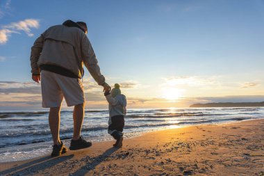 Babam gün doğumunda el ele tutuşarak sahilde yürüyordu. Sıcak ışık duygusal aile ortamı yaratır..