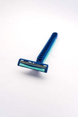 Kirli ve paslı, beyaz arka planda izole edilmiş kullanılmış tek kullanımlık tıraş bıçağı. Plastikten yapılmış ve bıyık ve sakal tıraşı için kullanılmış..