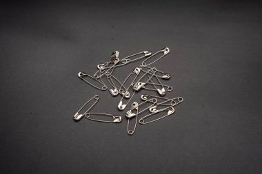 Karanlık arka planda izole edilmiş dağınık çengelli iğne yığınını kapat..