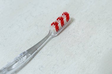 Beyaz arkaplanda izole edilmiş kırmızı ve beyaz plastik diş fırçası başı.