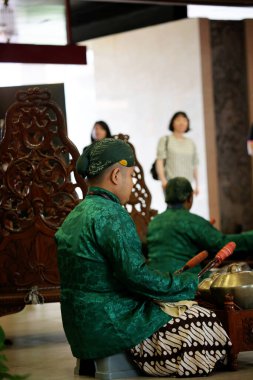 Jakarta, Indonesia. April 13, 2024. Artists play Gamelan Carabalen to welcome the arrival of tourists at the TMII tourist attraction, Jakarta. Tourists can play too. clipart