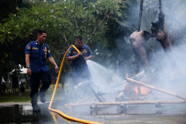 Jakarta, Endonezya. 21 Nisan 2024. İtfaiyeciler, Jakarta 'nın TMII turizm sahasında bir Ogoh-ogoh' u yutan bir yangını söndürüyor.