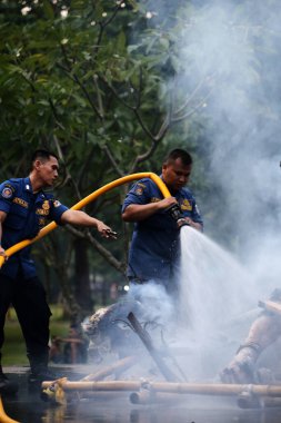 Jakarta, Endonezya. 21 Nisan 2024. İtfaiyeciler, TMII turistik merkezinde Ogoh-ogoh 'u yakan yangını söndürüyorlar, Jakarta.