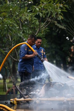 Jakarta, Endonezya. 21 Nisan 2024. TMII turizm merkezi Jakarta 'daki itfaiyeciler bir Ogoh-ogoh' u yakıp kül eden yangını söndürüyorlar.