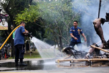 Jakarta, Endonezya. 21 Nisan 2024. TMII, Jakarta 'da itfaiyeciler bir Ogoh-ogoh' daki yangını söndürmek için çalışıyorlar.