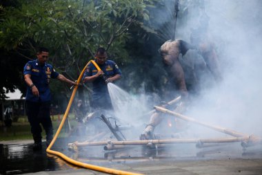 Jakarta, Endonezya. 21 Nisan 2024. Jakarta 'daki TMII' de itfaiyeciler bir Ogoh-ogoh 'u yakarak alevleri söndürüyorlar.