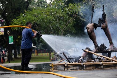 Jakarta, Endonezya. 21 Nisan 2024. İtfaiye ekibi TMII, Jakarta 'da yanan bir Ogoh-ogoh' a su püskürttü.