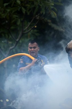 Jakarta, Endonezya. 21 Nisan 2024. Jakarta 'daki TMII' de itfaiyeciler bir Ogoh-ogoh 'u yakarak alevleri söndürüyorlar.