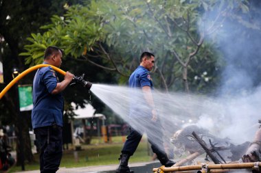 Jakarta, Endonezya. 21 Nisan 2024. Jakarta 'daki TMII' de itfaiyeciler bir Ogoh-ogoh 'u yakarak alevleri söndürüyorlar.