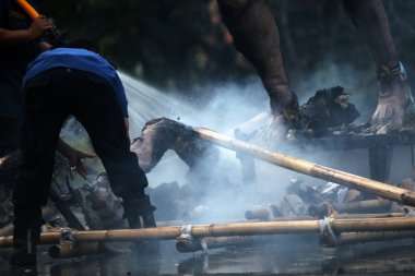 Jakarta, Endonezya. 21 Nisan 2024. TMII, Jakarta 'da itfaiyeciler bir Ogoh-ogoh' daki yangını söndürmek için çalışıyorlar.