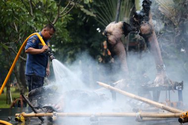 Jakarta, Endonezya. 21 Nisan 2024. TMII, Jakarta: İtfaiyeciler yanmış bir Ogoh-ogoh 'un üzerindeki alevleri söndürüyor