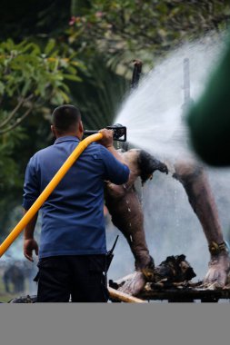 Jakarta, Endonezya. 21 Nisan 2024. TMII turizm merkezi Jakarta 'daki itfaiyeciler bir Ogoh-ogoh' u yakıp kül eden yangını söndürüyorlar.
