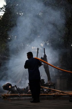 Jakarta, Endonezya. 21 Nisan 2024. İtfaiye ekibi TMII, Jakarta 'da yanan bir Ogoh-ogoh' a su püskürttü.