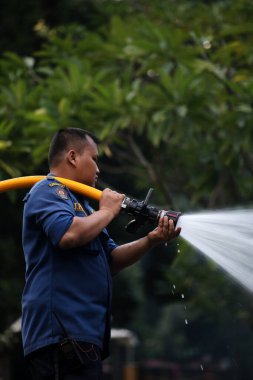 Jakarta, Endonezya. 21 Nisan 2024. İtfaiyeciler, TMII turistik merkezinde Ogoh-ogoh 'u yakan yangını söndürmek için yüksek basınçlı su püskürtüyorlar, Jakarta..