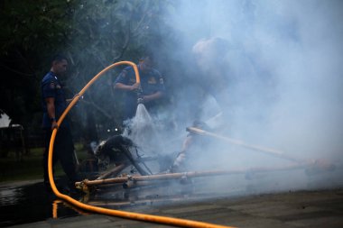 Jakarta, Endonezya. 21 Nisan 2024. İtfaiyeciler, TMII turistik merkezinde Ogoh-ogoh 'u yakan yangını söndürmek için yüksek basınçlı su püskürtüyorlar, Jakarta..