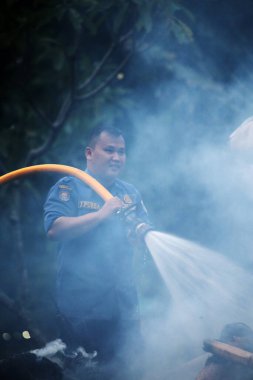 Jakarta, Endonezya. 21 Nisan 2024. İtfaiyeciler, TMII turistik merkezinde Ogoh-ogoh 'u yakan yangını söndürmek için yüksek basınçlı su püskürtüyorlar, Jakarta..