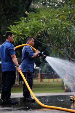 Jakarta, Endonezya. 21 Nisan 2024. İtfaiyeciler, TMII turistik merkezinde Ogoh-ogoh 'u yakan yangını söndürmek için yüksek basınçlı su püskürtüyorlar, Jakarta..